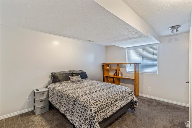 Carpeted bedroom featuring a textured ceiling and baseboards | Image 21