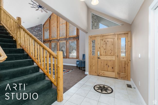 Tiled entryway featuring visible vents, baseboards, high vaulted ceiling, and stairs | Image 16