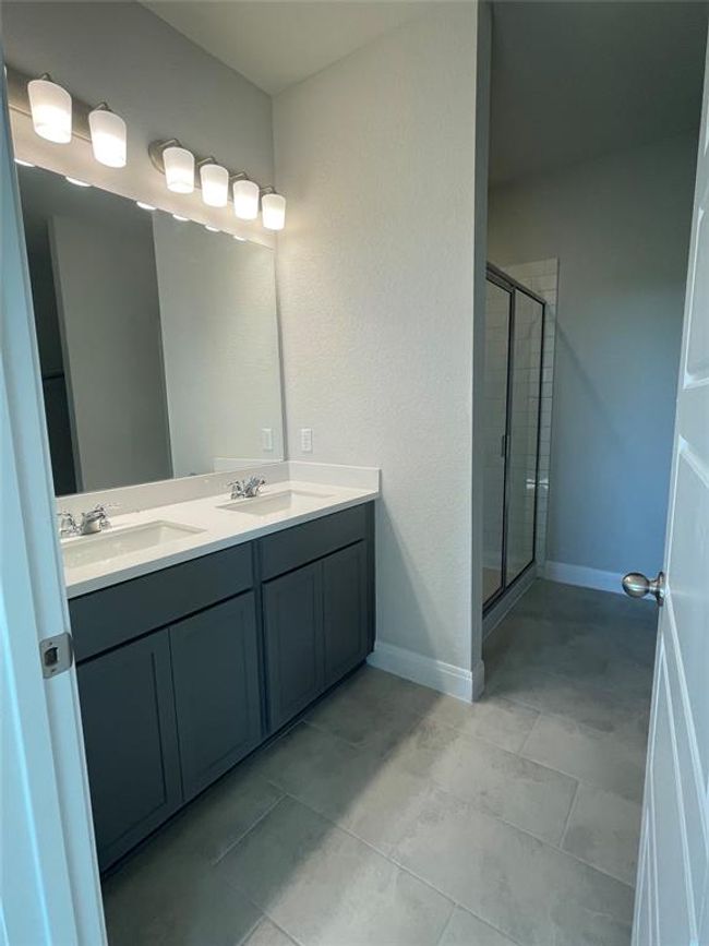 Full bathroom featuring a shower stall, double vanity, and tile patterned flooring | Image 9