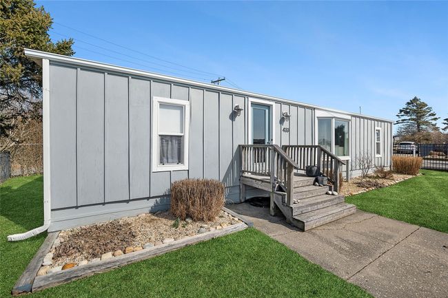 View of front facade with board and batten siding, a front lawn, and fence | Image 16
