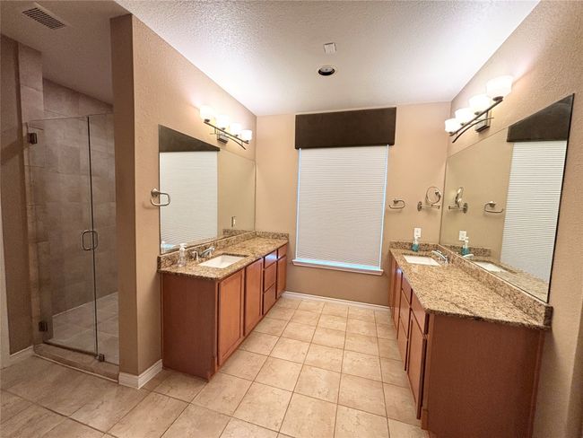 Bathroom featuring a shower stall, tile patterned floors, and two vanities | Image 15