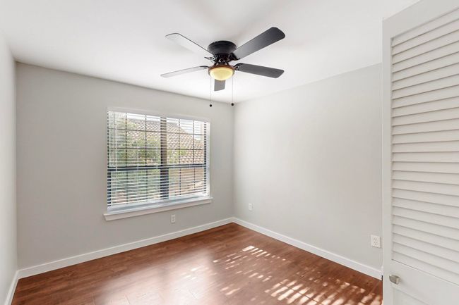 Empty room with wood finished floors, a ceiling fan, and baseboards | Image 31