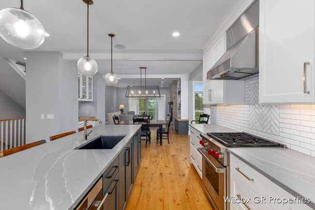 Hand crafted cabinetry, quartz countertops, tile splash, engineered wood floors, stainless appliances and 9' ceilings. | Image 12