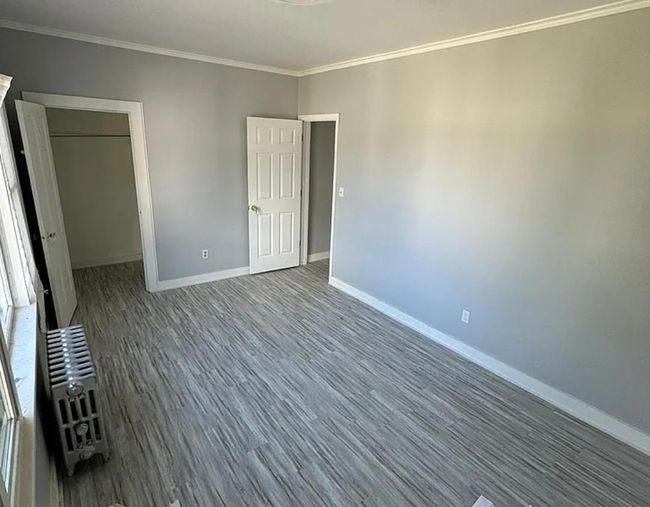 Unfurnished bedroom with baseboards, ornamental molding, and wood finished floors | Image 4