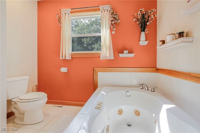 Full bath with a tub with jets and tile patterned floors | Image 38
