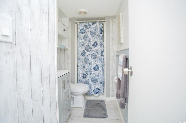 Bathroom featuring toilet, vanity, wood finished floors, and a shower with shower curtain | Image 27