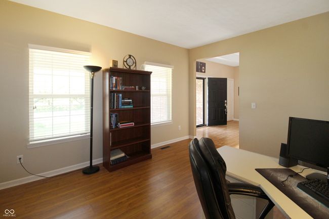 Enjoy a bright and welcoming atmosphere in this office, enhanced by laminate wood floors and ample natural light streaming in. | Image 4