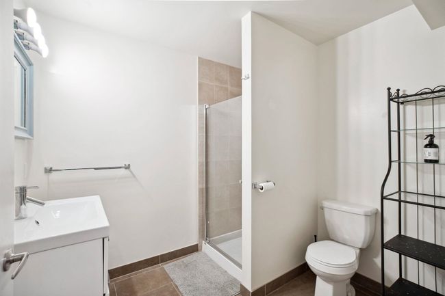Bathroom featuring baseboards, toilet, a shower stall, vanity, and tile patterned floors | Image 34