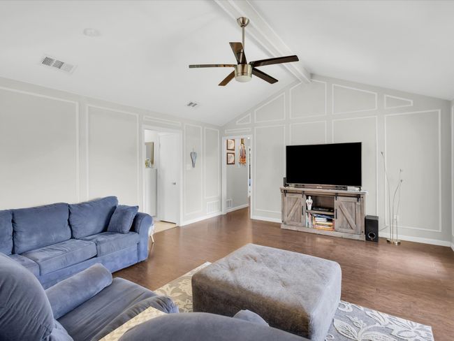 Living area with a decorative wall, a ceiling fan, and wood finished floors | Image 12