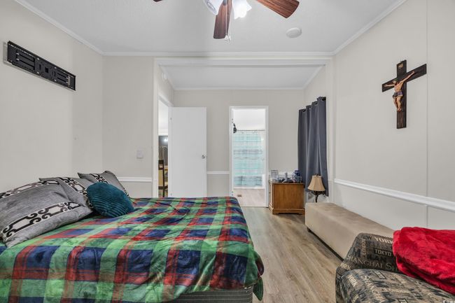 Bedroom featuring light wood-type flooring, ornamental molding, a ceiling fan, and connected bathroom | Image 13