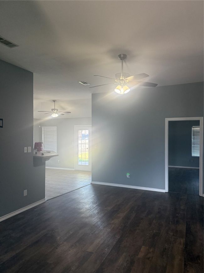 Empty room with ceiling fan, dark wood-style floors, and baseboards | Image 14