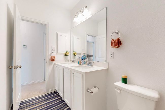 Bathroom featuring toilet, double vanity, and a sink | Image 27