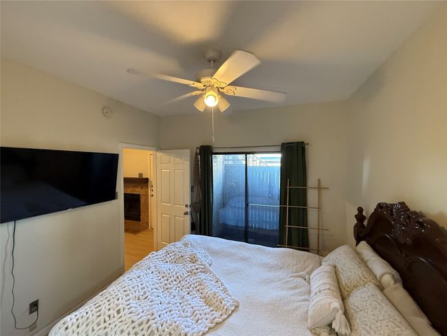 Bedroom with a ceiling fan, access to exterior, and a fireplace | Image 14