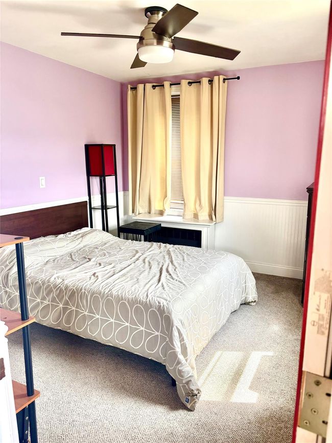 Bedroom featuring a wainscoted wall, carpet flooring, and ceiling fan | Image 16
