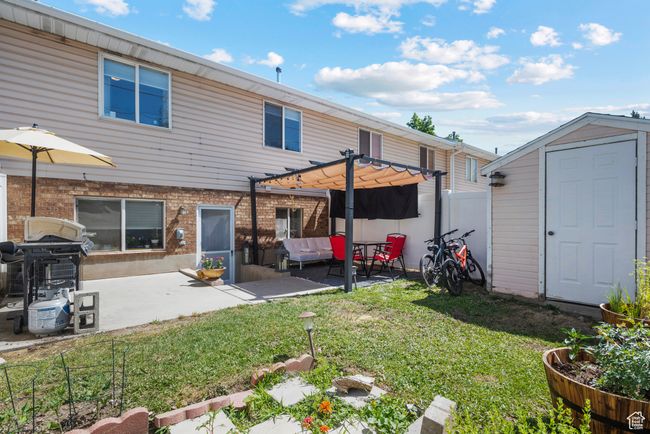 Rear view of house featuring a storage shed, a pergola, and a patio | Image 23