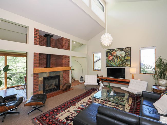 Carpeted living room with a towering ceiling | Image 8