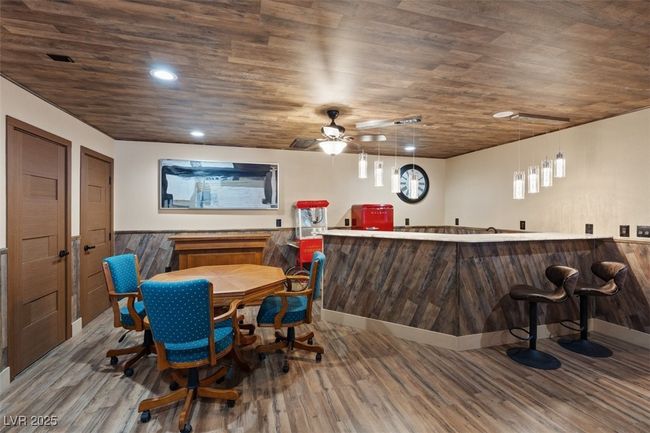 Dining room featuring wet bar, a wainscoted wall, recessed lighting, and wood finished floors | Image 42