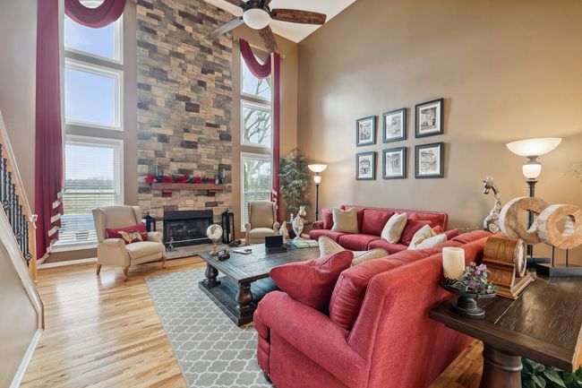 Welcoming 2-story great room with a cozy fireplace and tons of light from the floor-to-ceiling windows. Fireplace was renovated with new stone & hearth. | Image 7