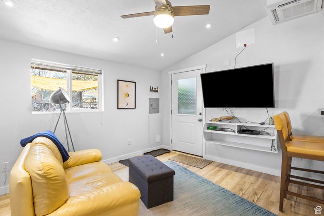 Living room featuring a ceiling fan, visible vents, recessed lighting, wood finished floors, and lofted ceiling | Image 20