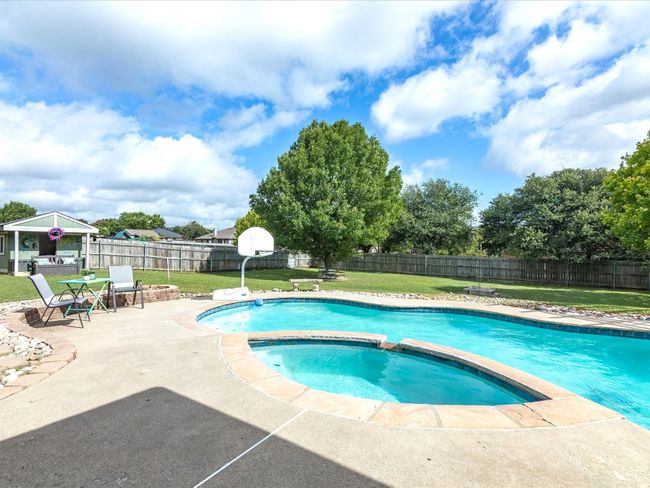 View of pool featuring a patio, a fenced backyard, a pool with connected hot tub, and a gazebo | Image 34