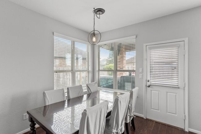 Charming breakfast area, complete with wood floors, and beautiful views of the backyard provided by several windows with privacy blinds. | Image 8