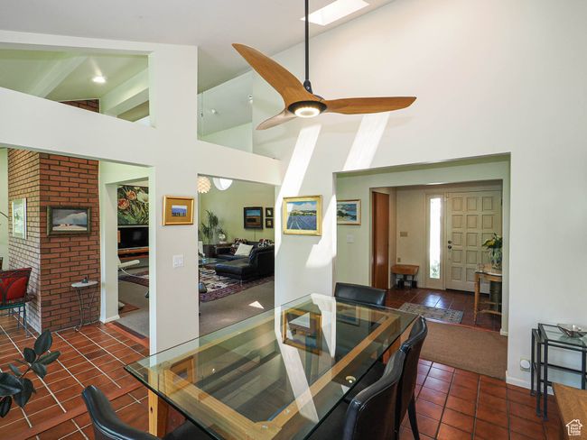 Tiled dining room with high vaulted ceiling and a ceiling fan | Image 15