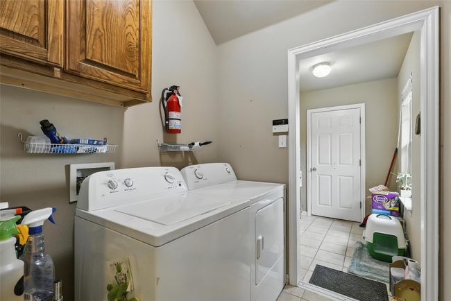 Laundry room featuring cabinet space, washing machine and clothes dryer, and light tile patterned flooring | Image 21