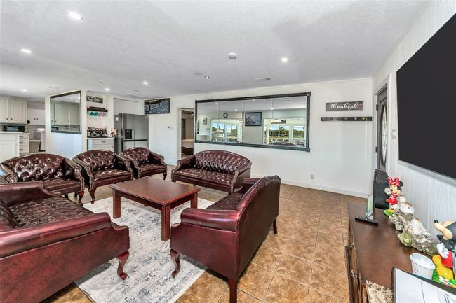 Living room with light tile patterned floors, a textured ceiling, and recessed lighting | Image 23
