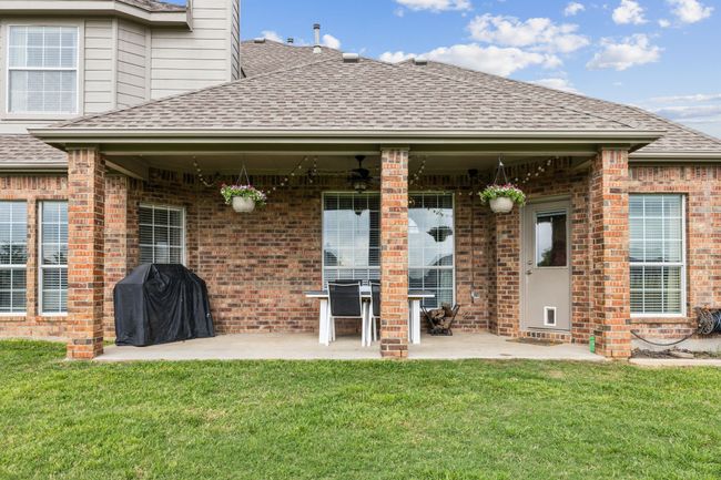 Back of house with brick siding, roof with shingles, a patio area, and a yard | Image 31