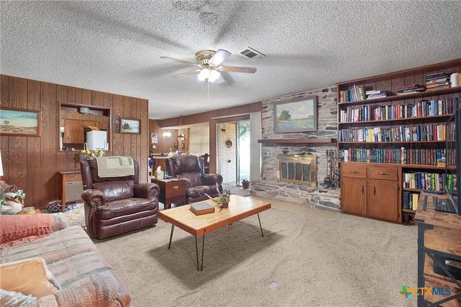 Living room with wood-burning fireplace and built-in bookcase | Image 12