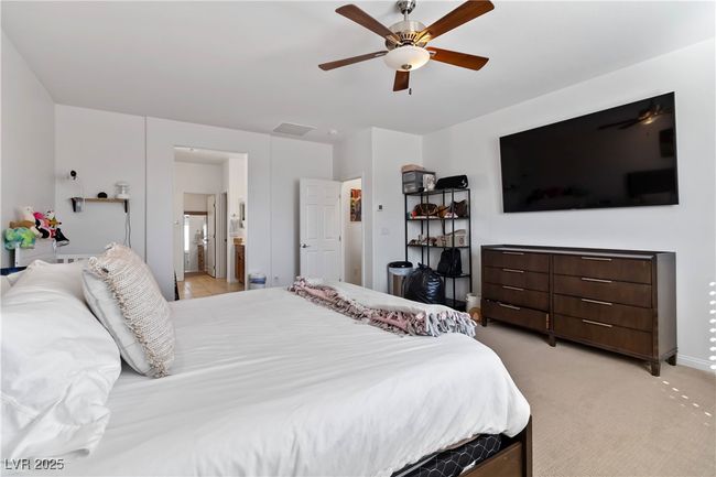 Bedroom with light carpet, baseboards, visible vents, a ceiling fan, and ensuite bath | Image 23