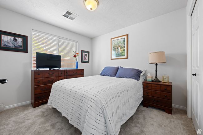 Bedroom featuring baseboards, visible vents, light carpet, and a closet | Image 16