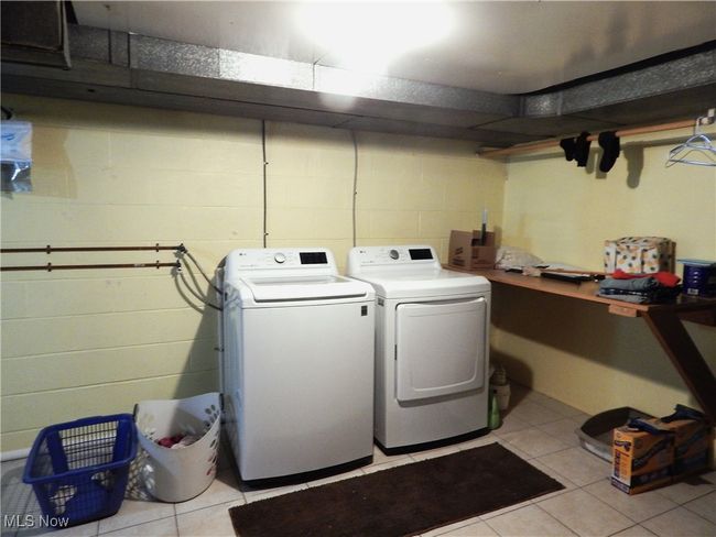 Laundry room featuring Newer LG Washer/Dryer remaining, Osmosis System, light tile patterned floors. | Image 28