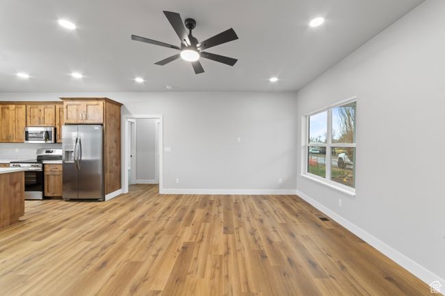Kitchen featuring light countertops, recessed lighting, light wood-style flooring, appliances with stainless steel finishes, and brown cabinetry | Image 7