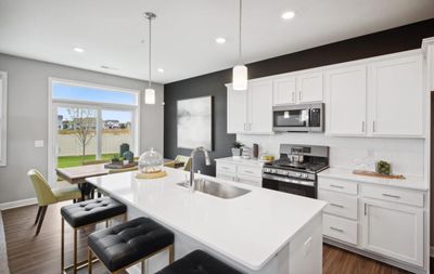 (Photo of decorated model, actual home's finishes will vary) This spacious kitchen features a large center island, quartz countertops, under mount sink, recessed lighting, LVP floors, stainless appliances and more. | Image 2