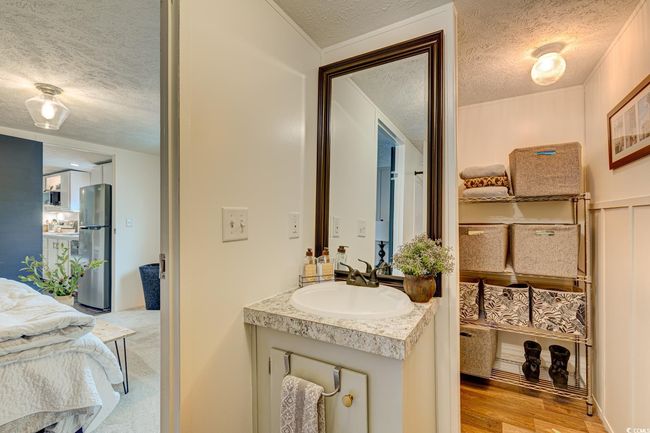 Bathroom featuring a textured ceiling, vanity, and wood finished floors | Image 18
