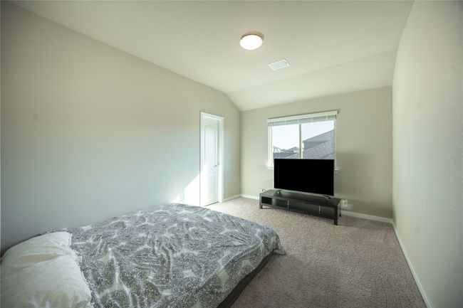 Carpeted bedroom featuring lofted ceiling | Image 25