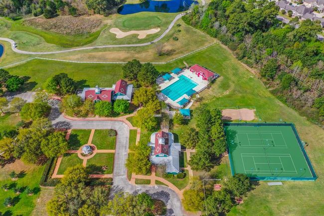 This aerial view shows a picture of ONE of the two community center areas in Windrose. Here you can see our Meeting House, Club House, courtyard area, 1 of 2 of the pools in the community, &tennis courts. PLUS there is a large green space for soccer goals. | Image 44