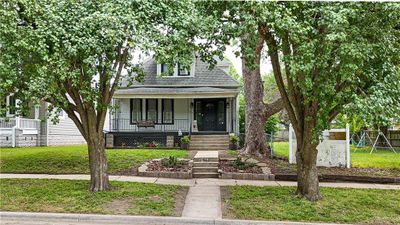 Bungalow-style house with covered porch and a front yard | Image 1