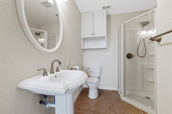 Bathroom with visible vents, tile patterned flooring, a shower stall, and toilet | Image 15