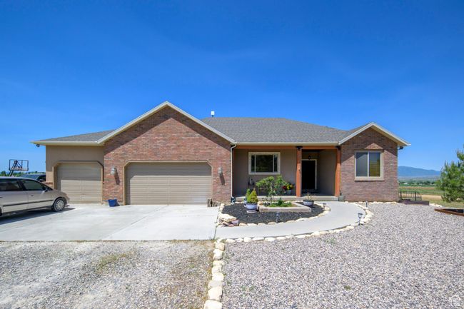 Ranch-style home with an attached garage, concrete driveway, brick siding, and a shingled roof | Image 30