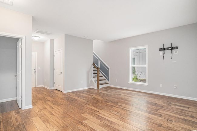 Unfurnished living room with stairway and light wood-type flooring | Image 19