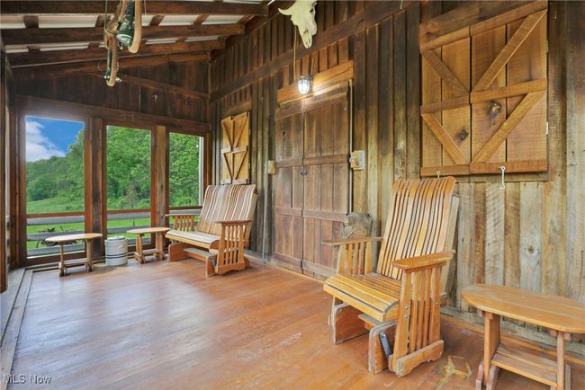 Living area with wood walls, wood finished floors, and lofted ceiling | Image 26