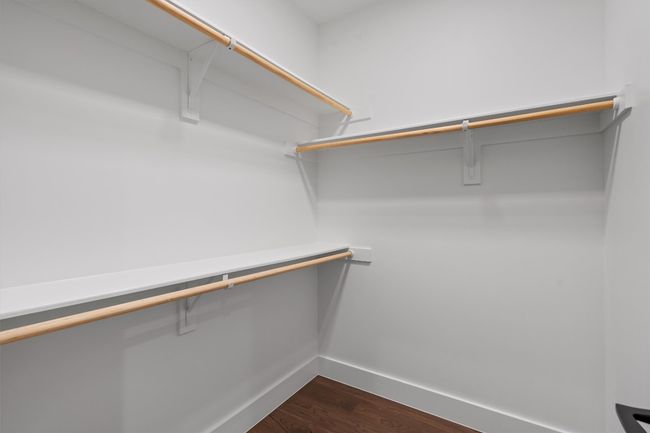 Spacious closet with dark wood finished floors | Image 28