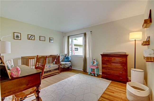 Bedroom with light wood finished floors and a baseboard radiator | Image 27