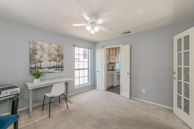 Carpeted home office with a ceiling fan and baseboards | Image 9