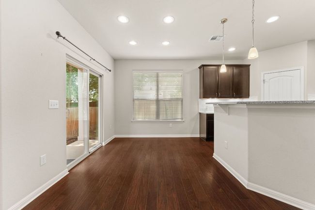 Kitchen featuring dark wood-style flooring, recessed lighting, baseboards, dark brown cabinetry, and decorative light fixtures | Image 9