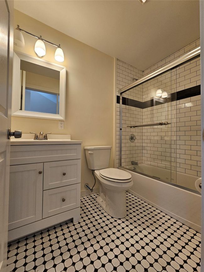 Full bathroom with vanity, combined bath / shower with glass door, and toilet | Image 4