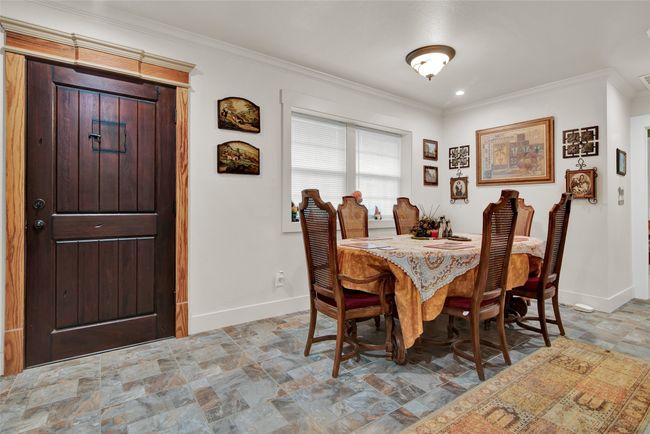 Just off the kitchen, the formal dining area is also a central area in this home. Notice the beautiful entry door and the attention to detail in the framing of that door. | Image 16
