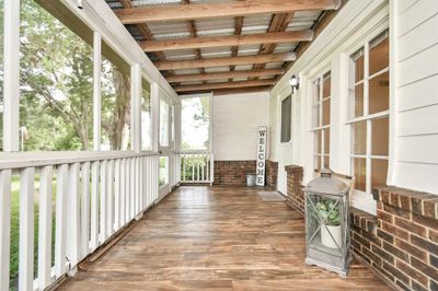 Enjoy the tranquil views from the front screened porch. Utility room for washer and dryer is located in one of the sides of the porch. | Image 2